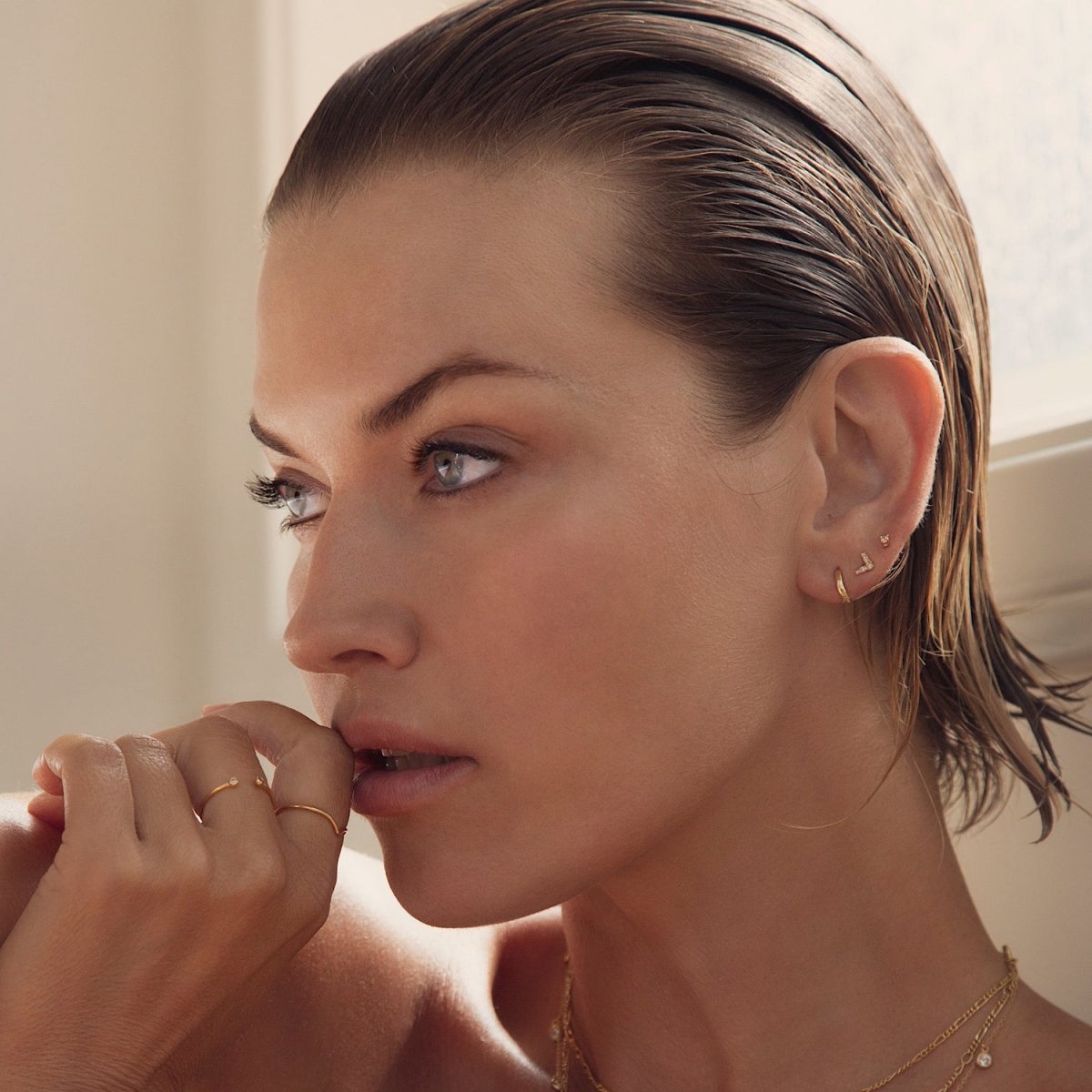 14K gold V-shaped chevron diamond stud shown on a model's upper lobe