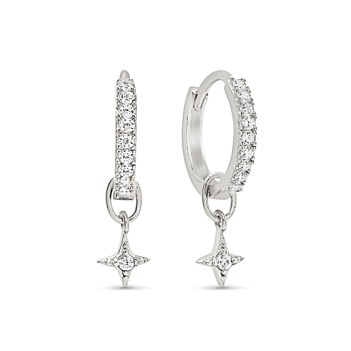 Sterling silver pavé huggie hoops with hanging starburst charms set with clear stones, on a white background