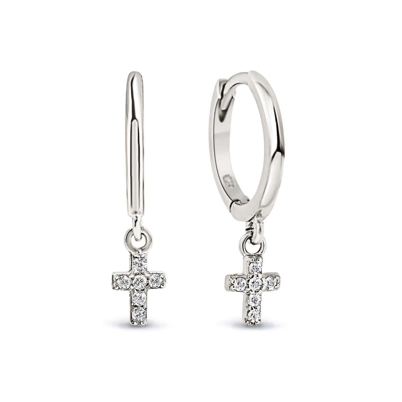 Sterling silver huggie hoops with a dangling cross of clear white zirconia, on a white background