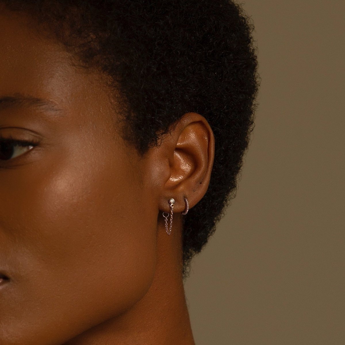 Sterling silver bezel chain stud earring shown on a model's lobe, side profile view