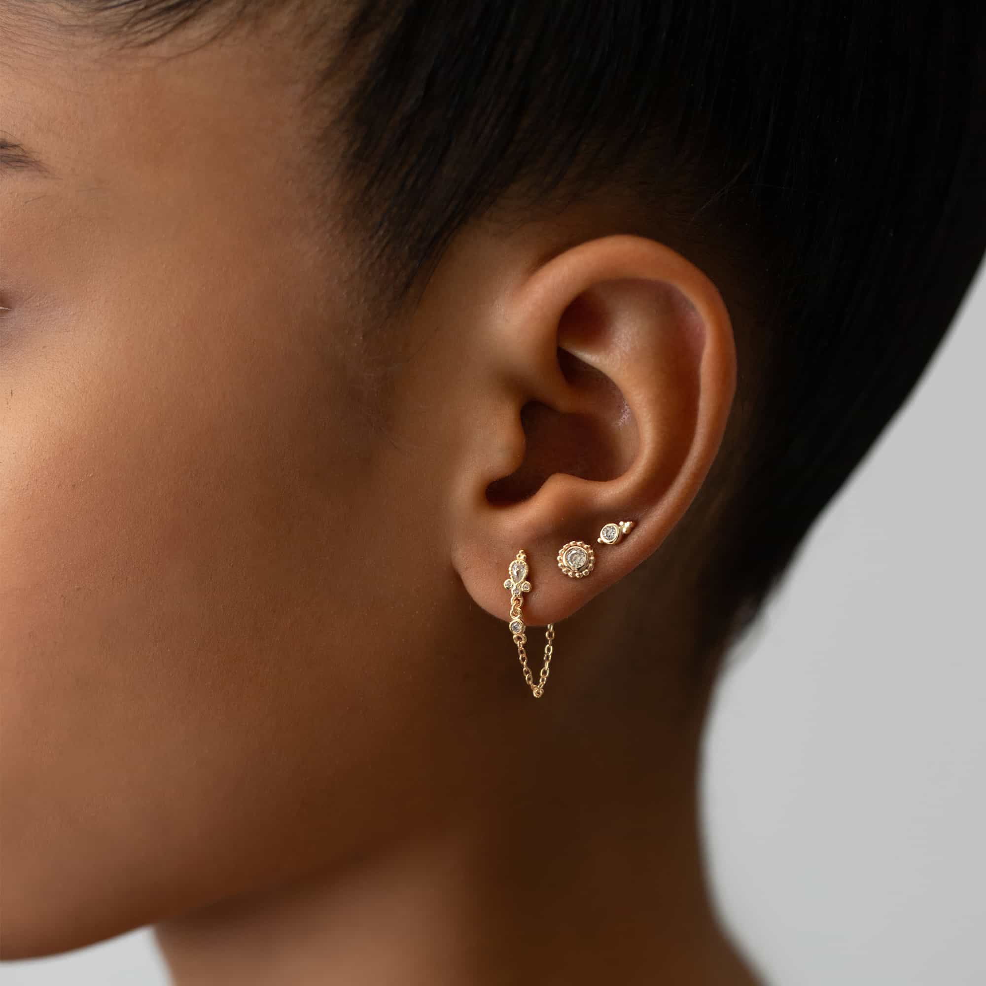 Rose gold vermeil bezel zirconia stud shown on a model's lobe in a curated ear stack