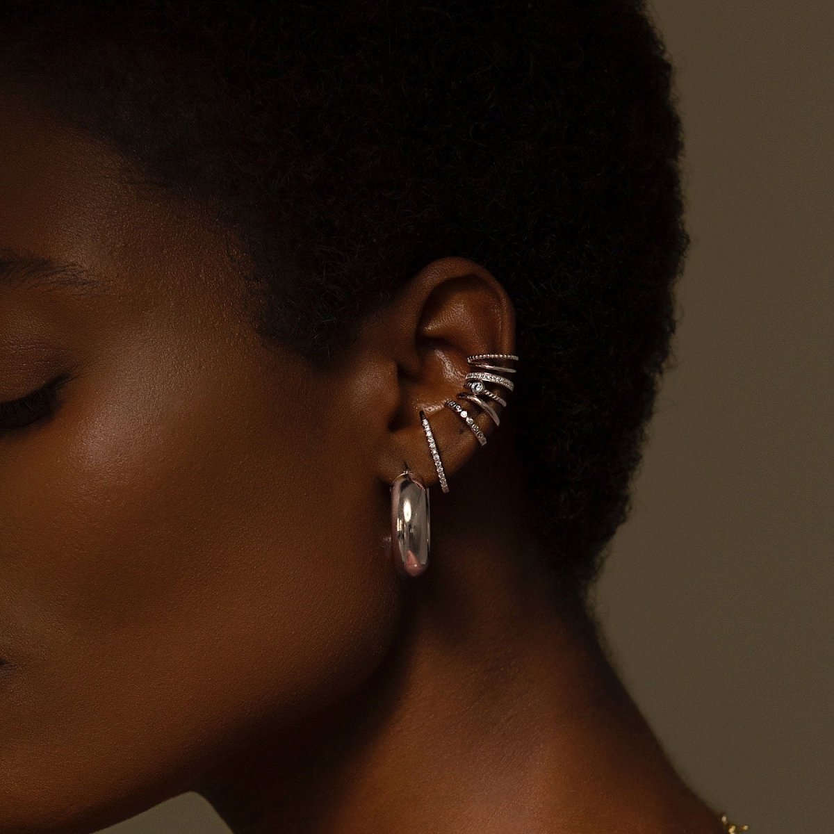 Sterling silver white zirconia ear conch cuffs stacked on a model's conch and lobe