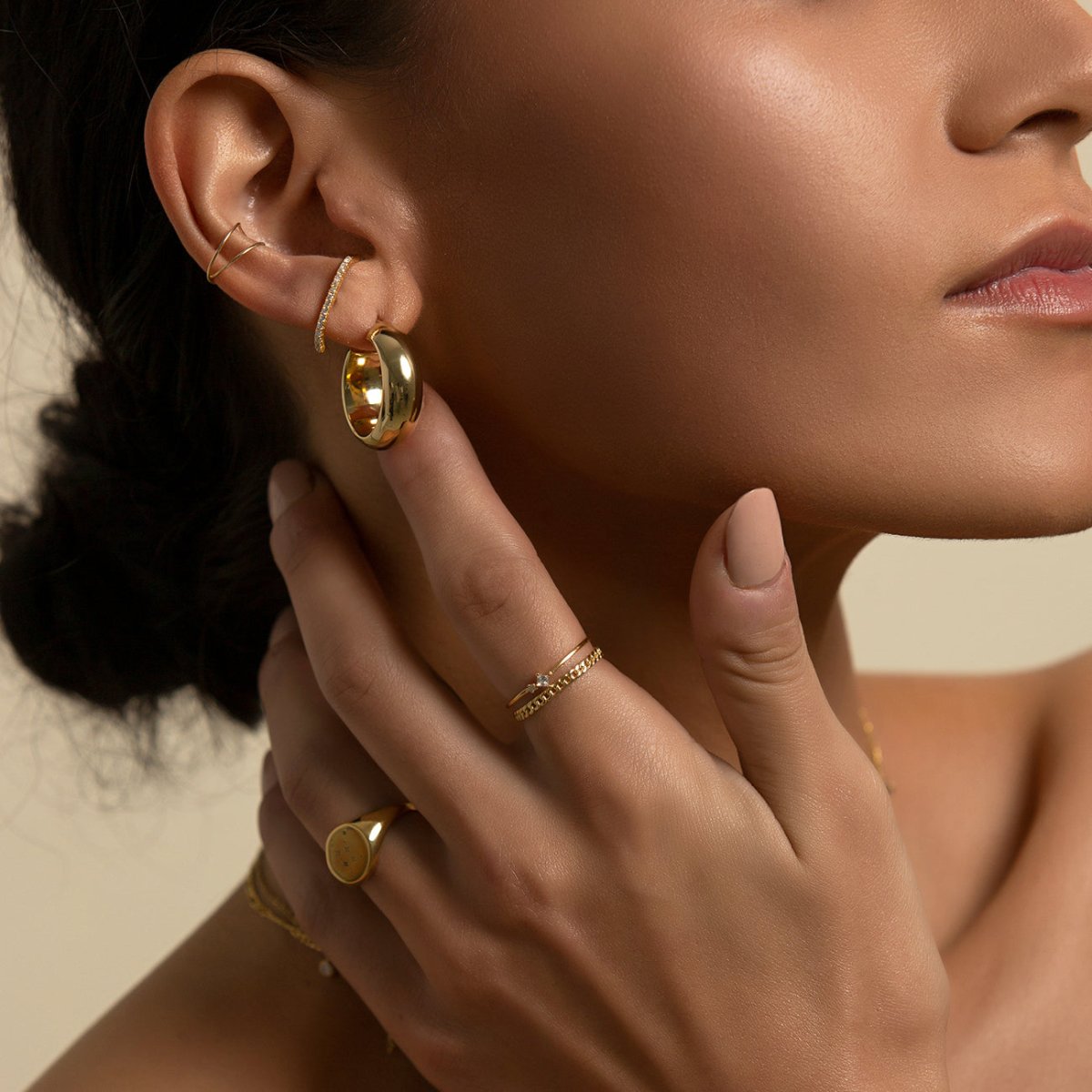 14K gold double-band ear cuff styled in an ear stack, shown on a model's ear