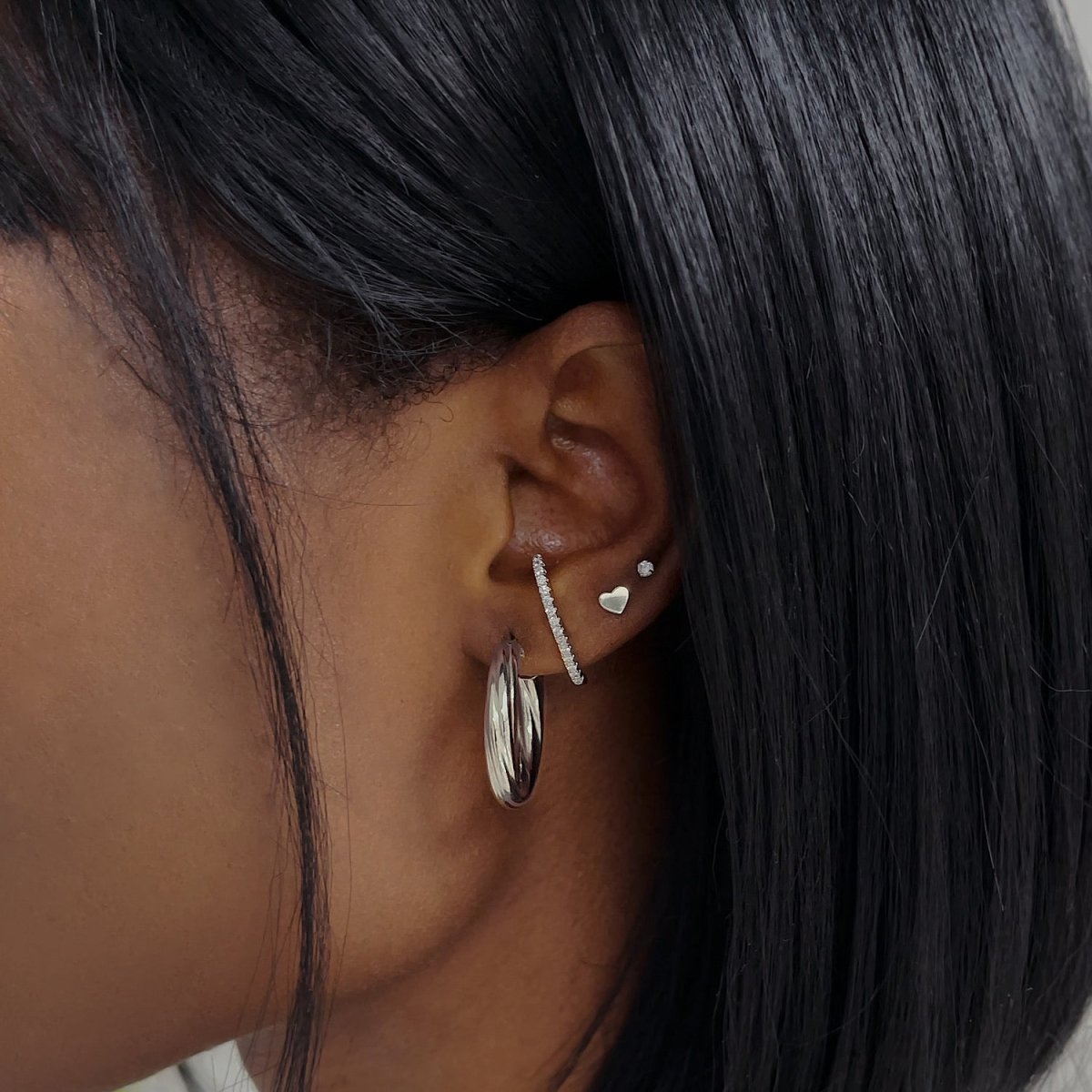 Sterling silver pave suspender earring with clear crystals, shown climbing a model's lobe
