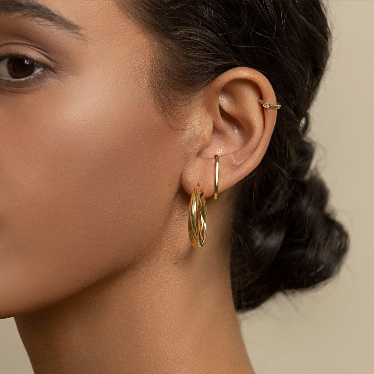 Gold vermeil thin hoop earring shown on a model's lobe with a slim ear cuff above