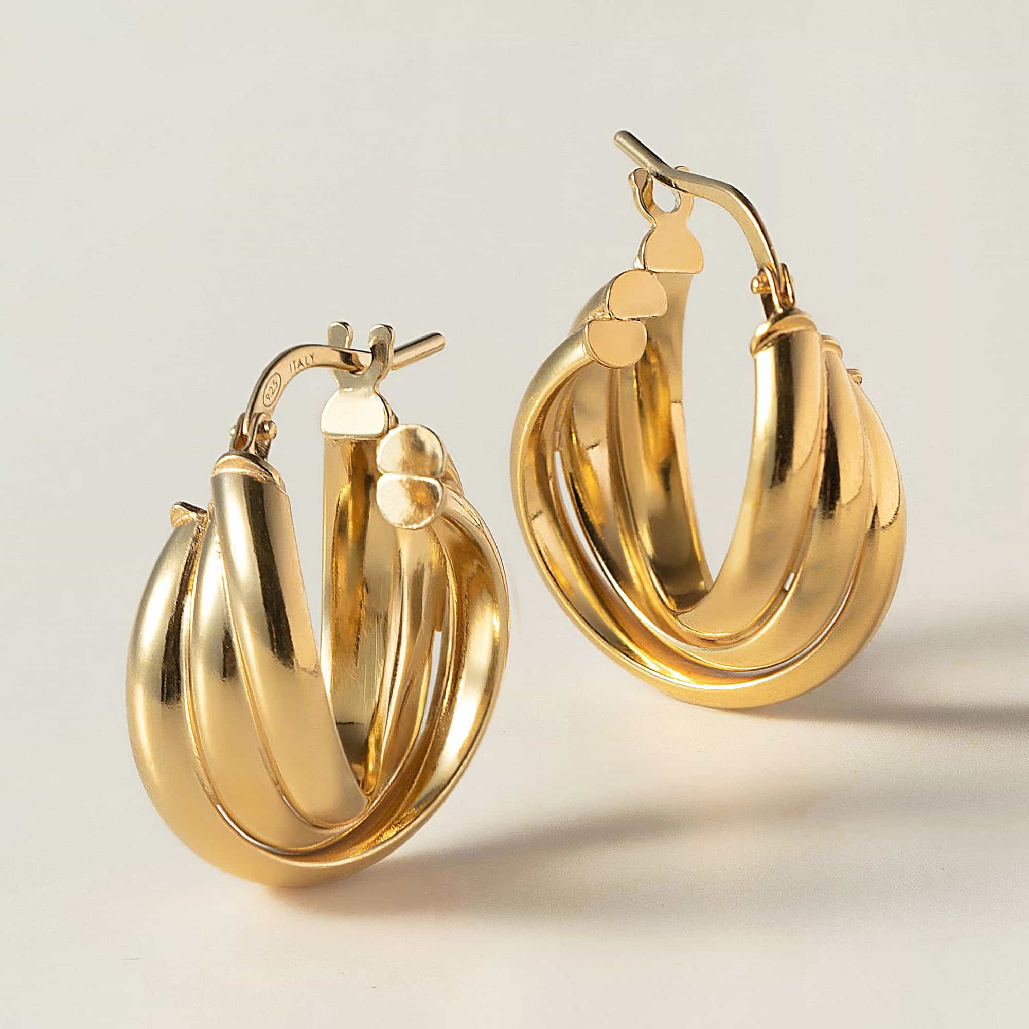 Gold vermeil chunky twisted-rope hoop earrings, close-up detail on a cream background