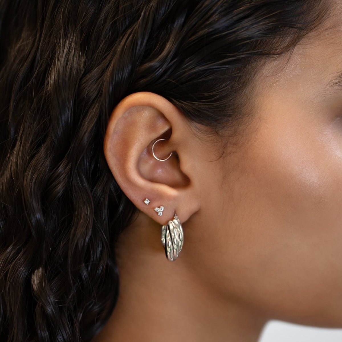 Sterling silver chunky twisted-rope hoop with studs, styled on a model's ear