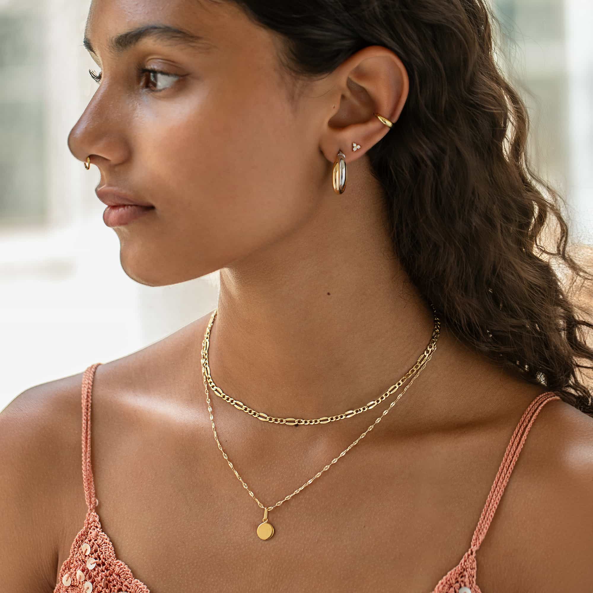 Gold vermeil and silver twist hoop with layered gold chains, shown on a model
