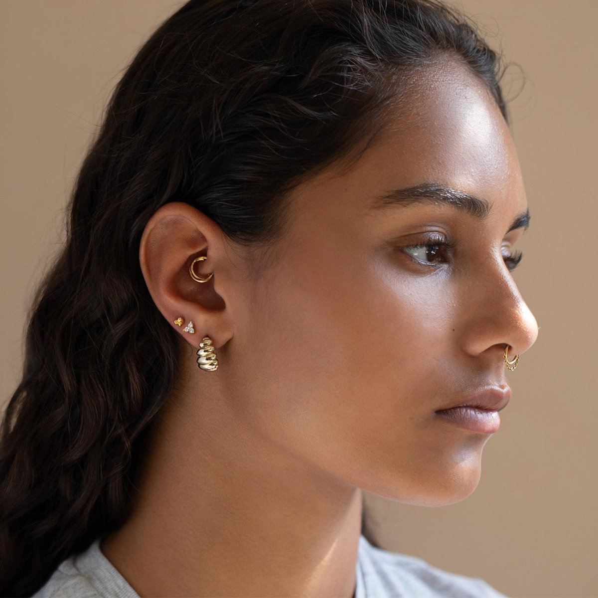 Gold vermeil croissant dome stud earring shown on a model's lobe with a gold ear cuff