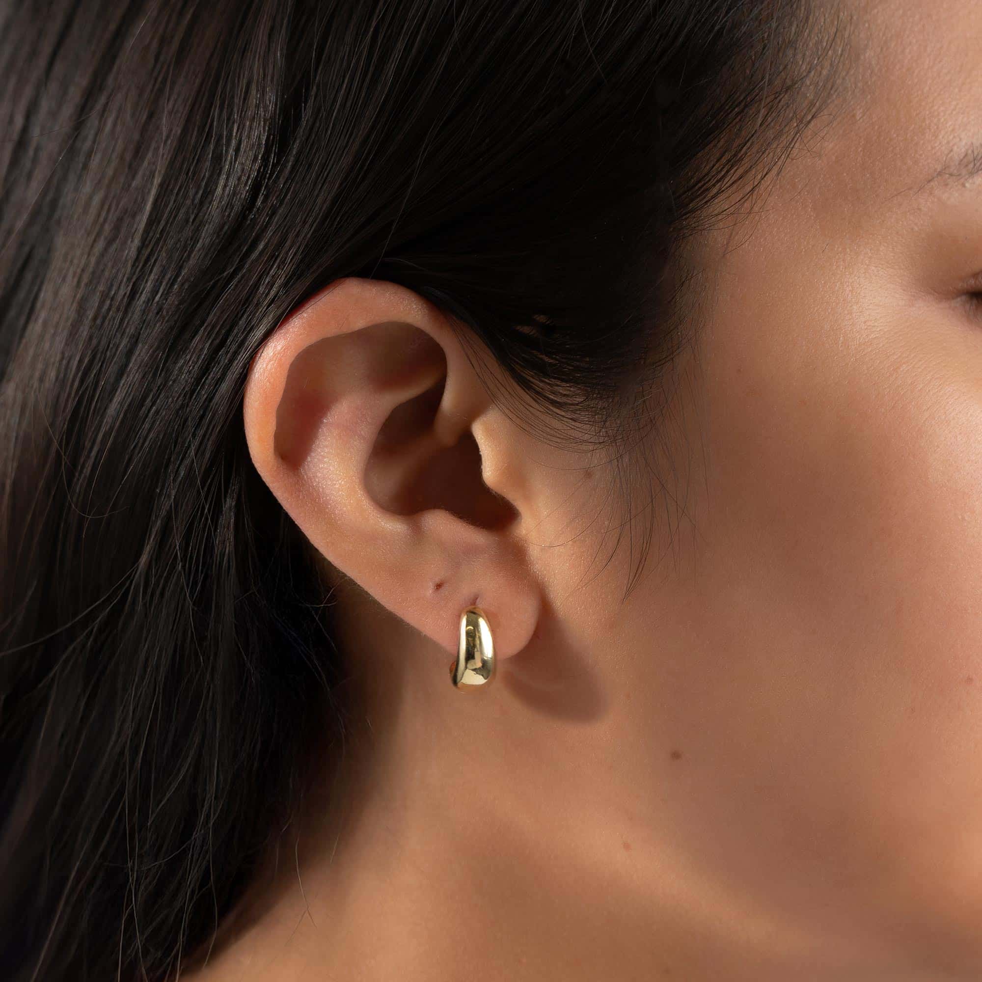 Gold vermeil chunky J-hoop earring shown on a model's lobe