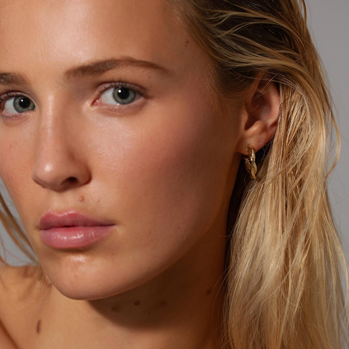 Gold vermeil twisted rope C-hoop earring shown on a model's lobe