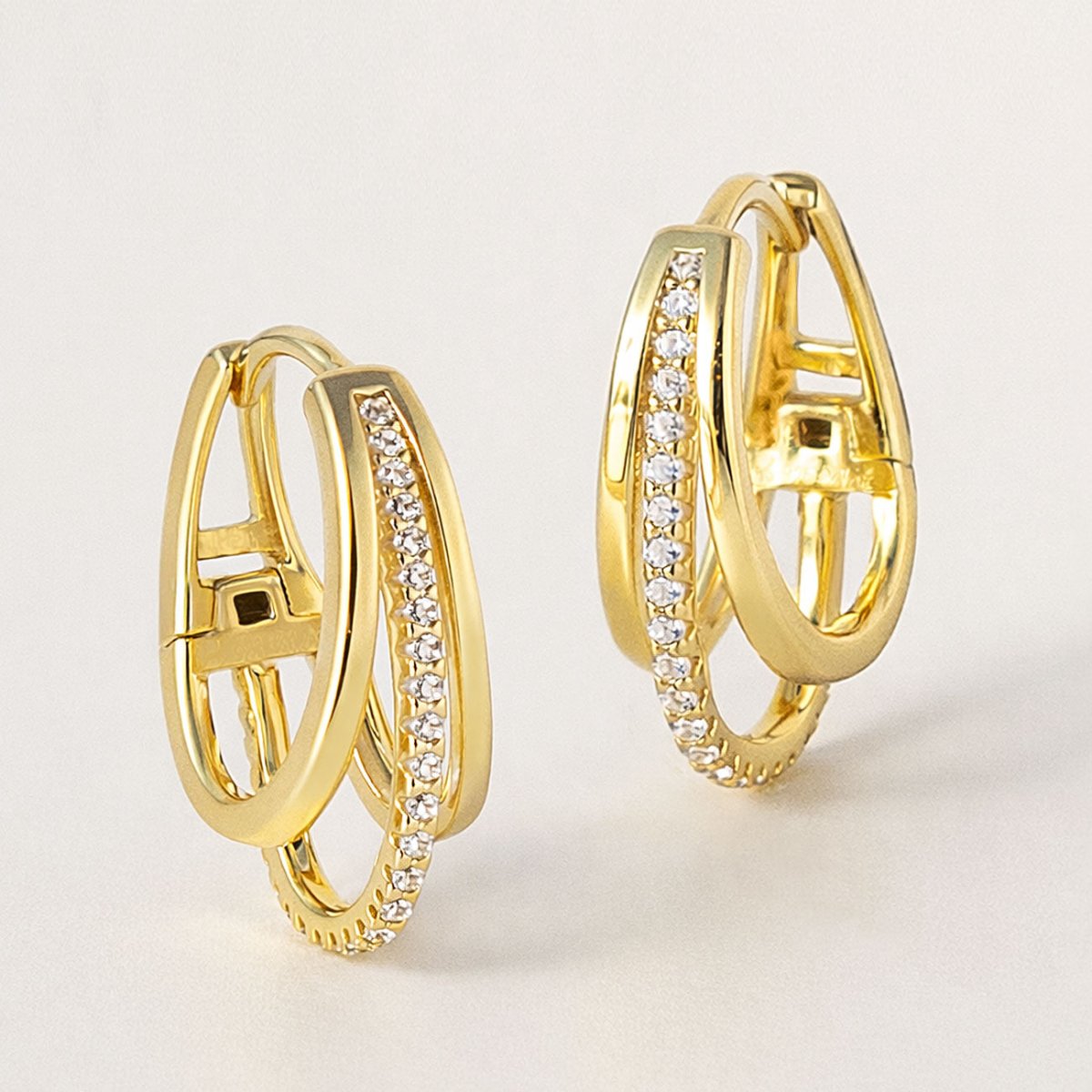 Gold vermeil pave triple mini hoops with a crystal-set band, close-up detail on a cream background