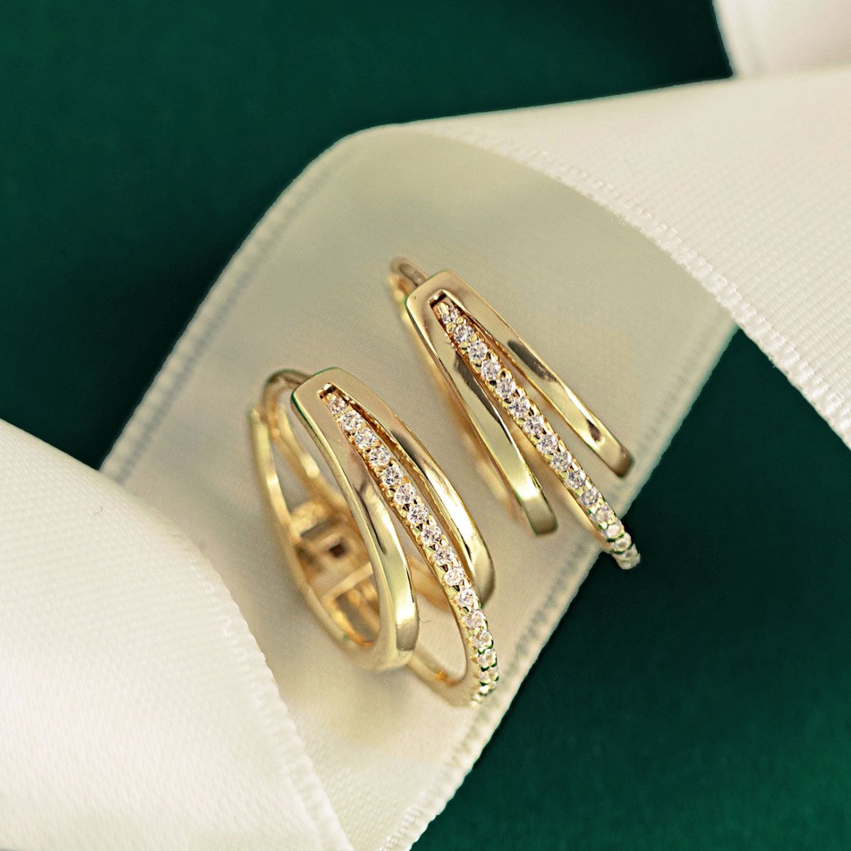 Gold vermeil pave triple mini hoops with clear crystals, shown on a model's ear