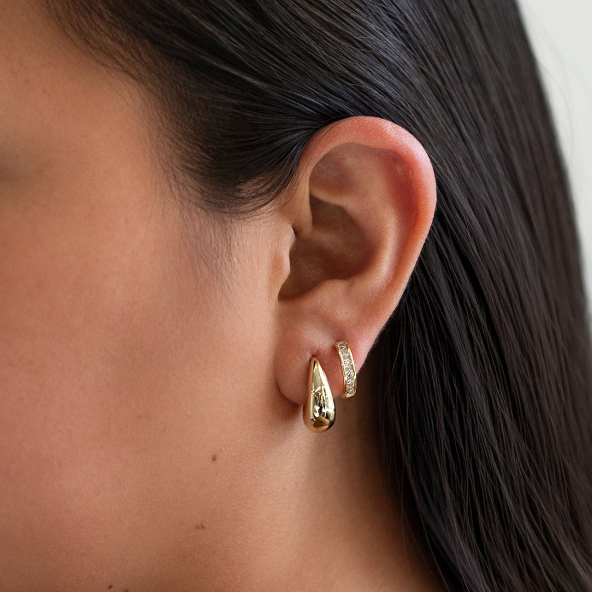 Gold vermeil chunky tapered teardrop hoop earring, shown on a model's lobe