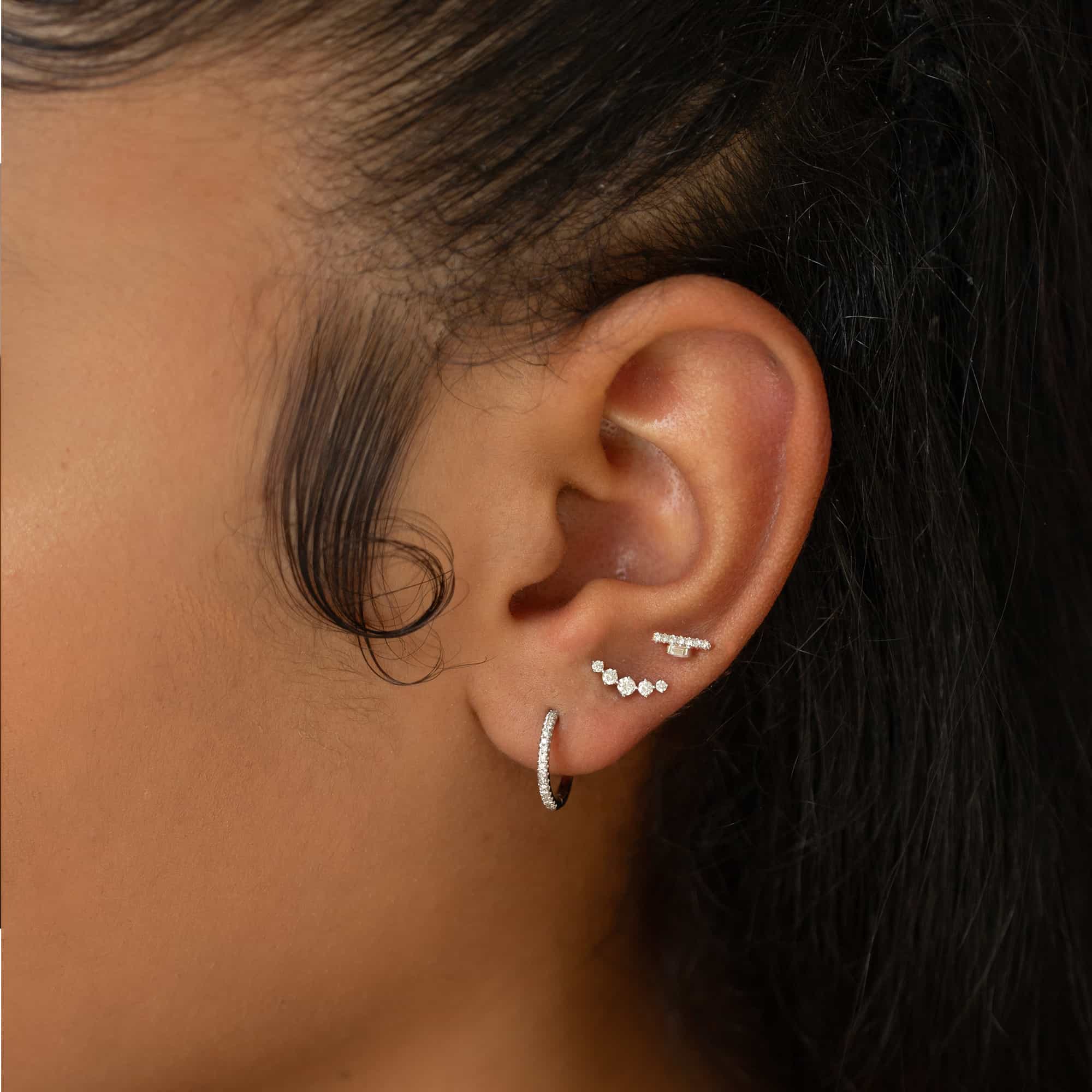 14K white gold diamond baguette bar stud shown on a model's lobe in an ear stack