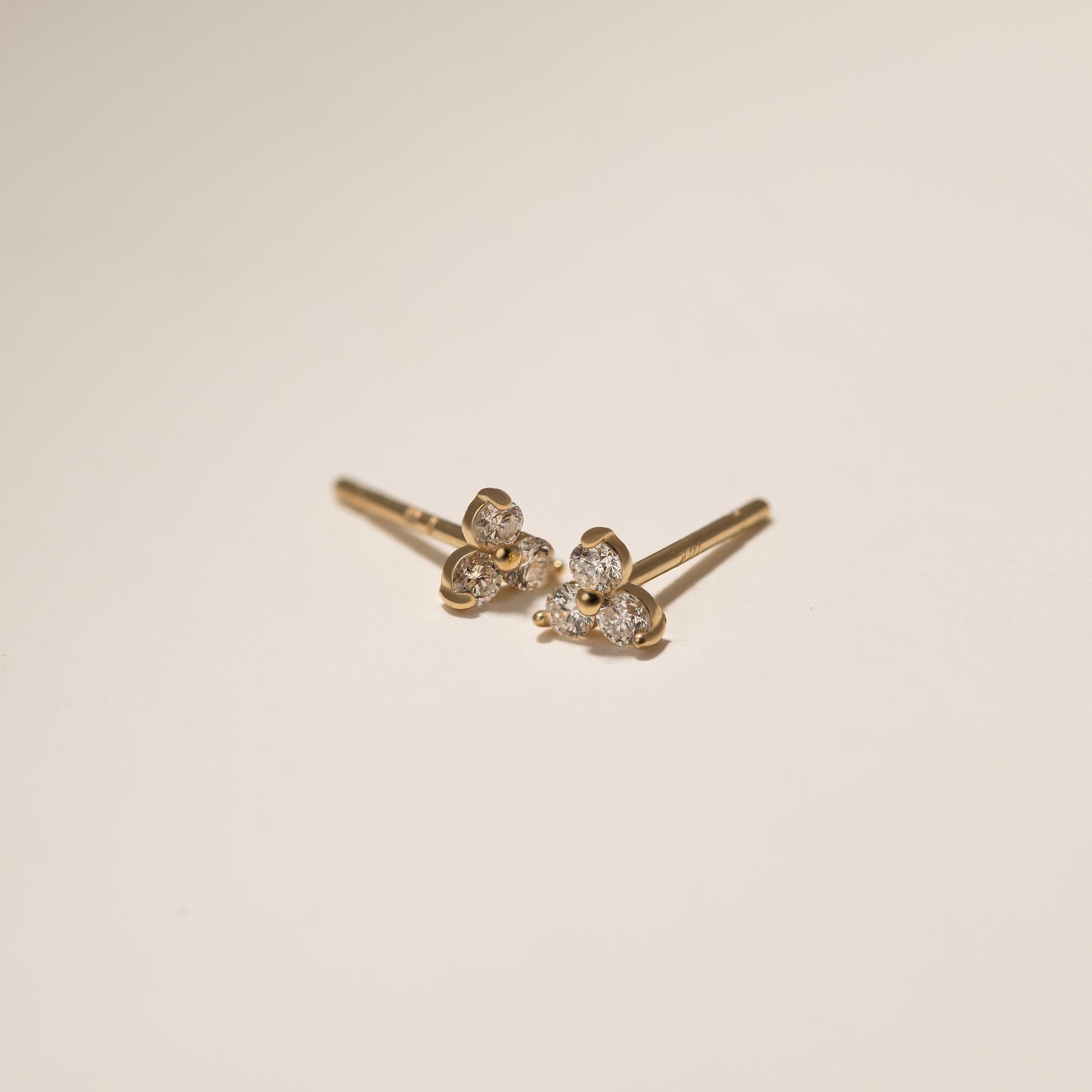 Close up of earring featuring 14K Gold Tiny Gold Clover Stud Earrings