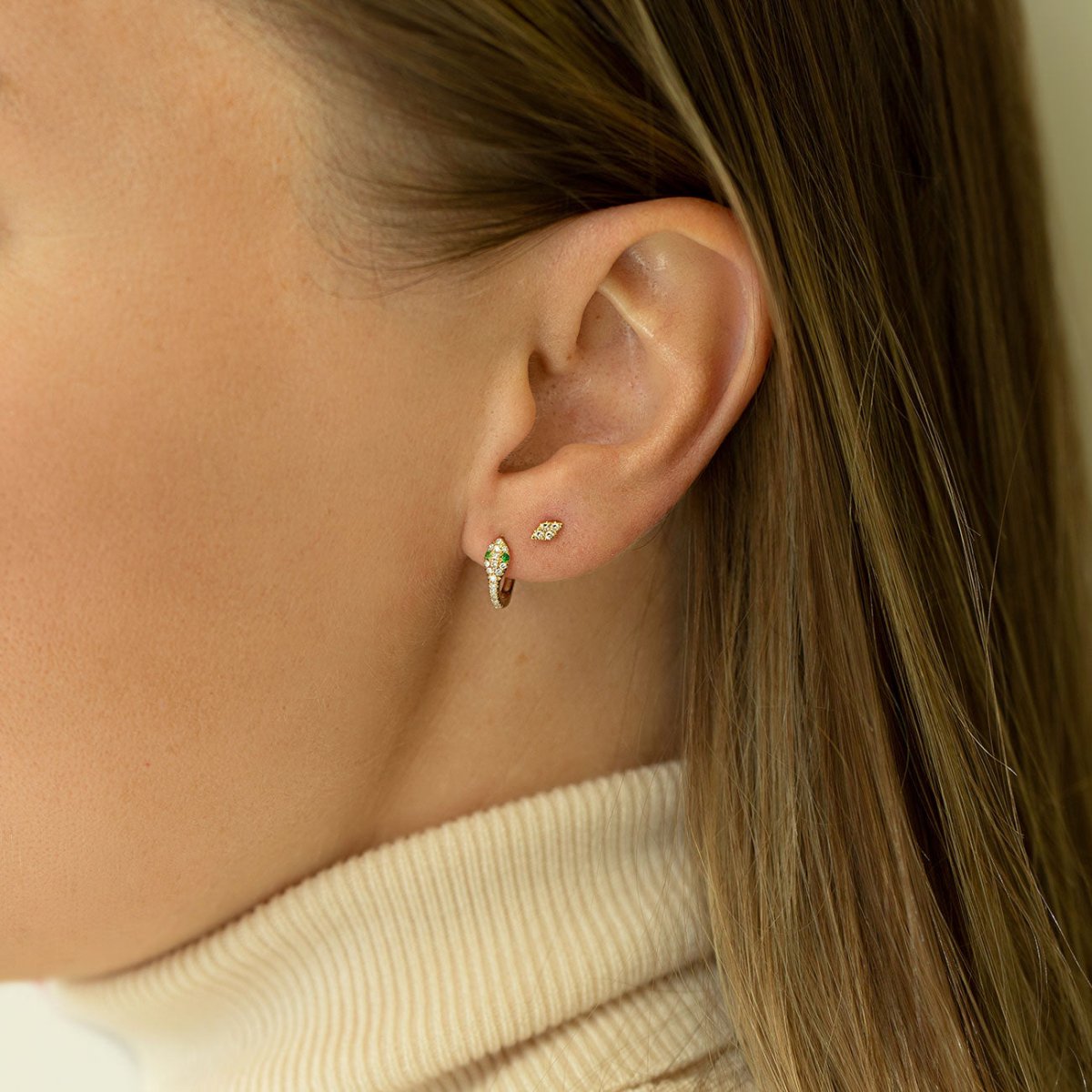 Gold vermeil pavé snake huggie hoop with clear stones, shown on a model's ear lobe