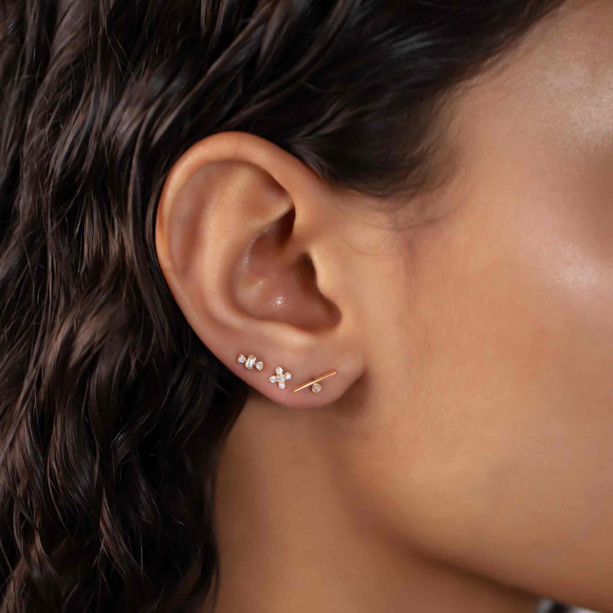 14K gold diamond bar stud shown on a model's ear in a stud stack