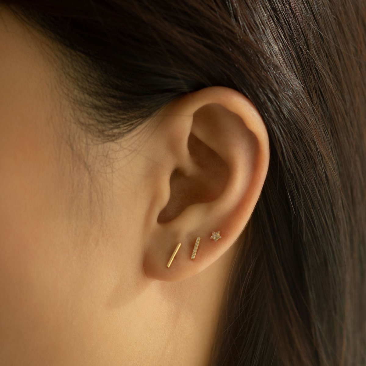 14K gold diamond pavé bar stud shown on a model's lobe in an ear stack
