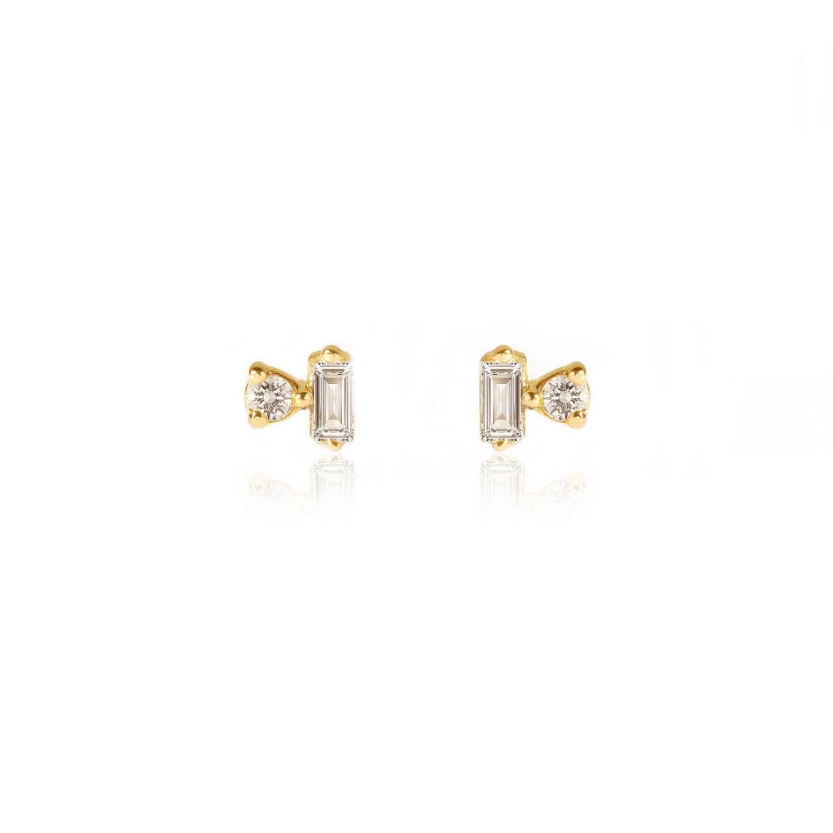 Pair of 14K gold baguette and round diamond duet studs, on a white background