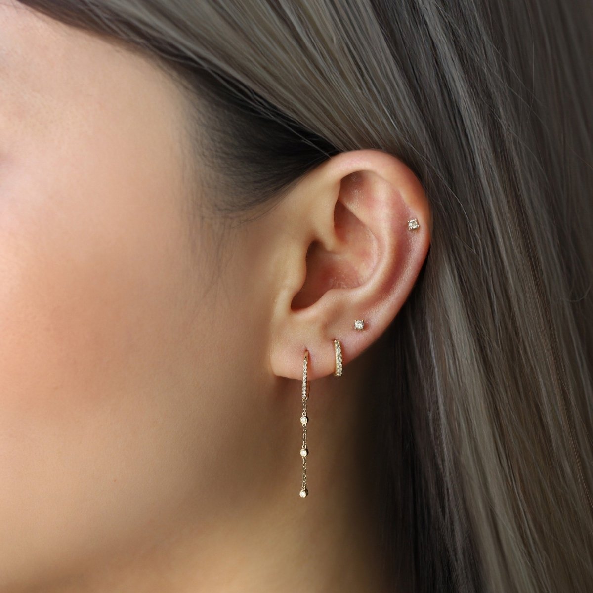14K gold pavé diamond drop threader earring with bezel diamonds, shown on a model's lobe