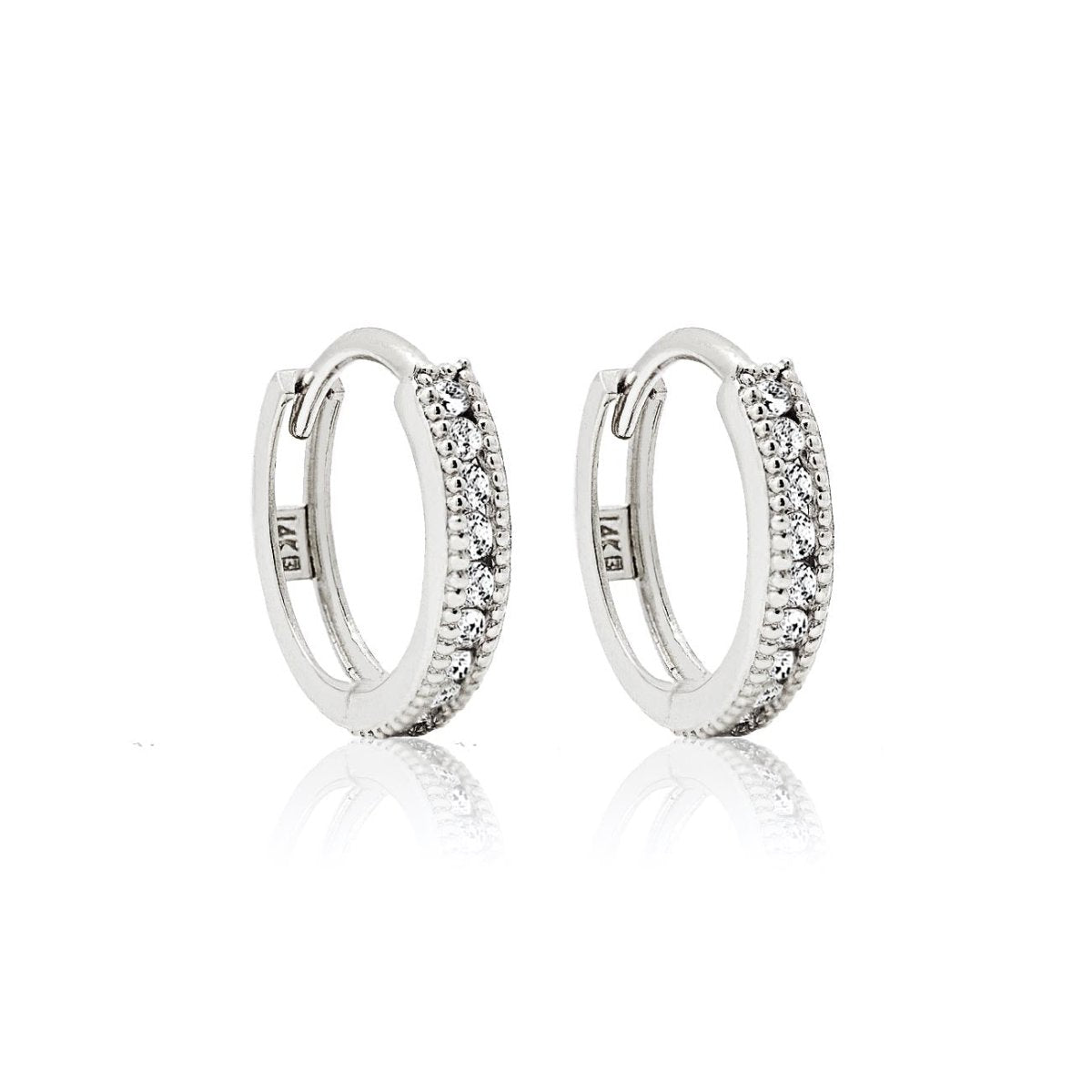Pair of 14K white gold milgrain huggie hoops paved with natural diamonds, on a white background