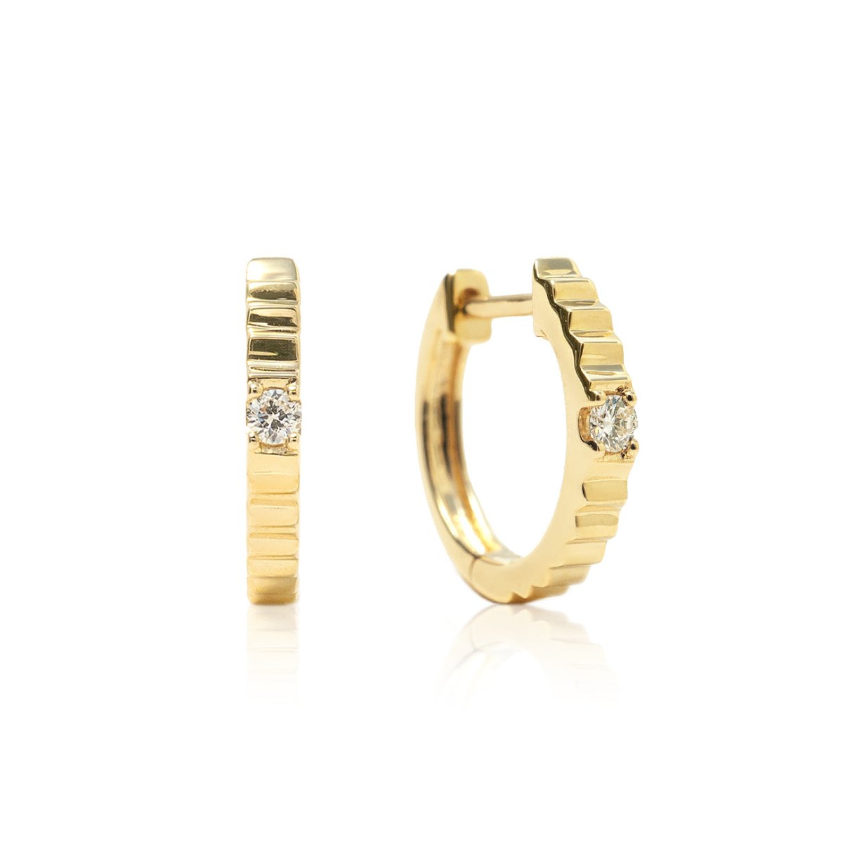 Pair of 14K gold ridge-textured diamond huggie hoops with a single stone, on a white background