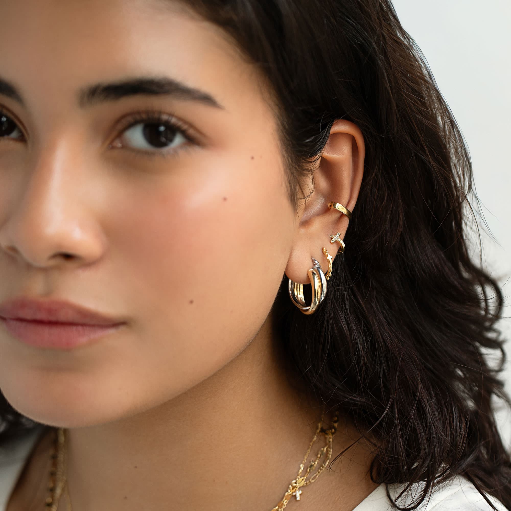 Gold vermeil and silver two-tone twist hoop, shown on a model's lobe