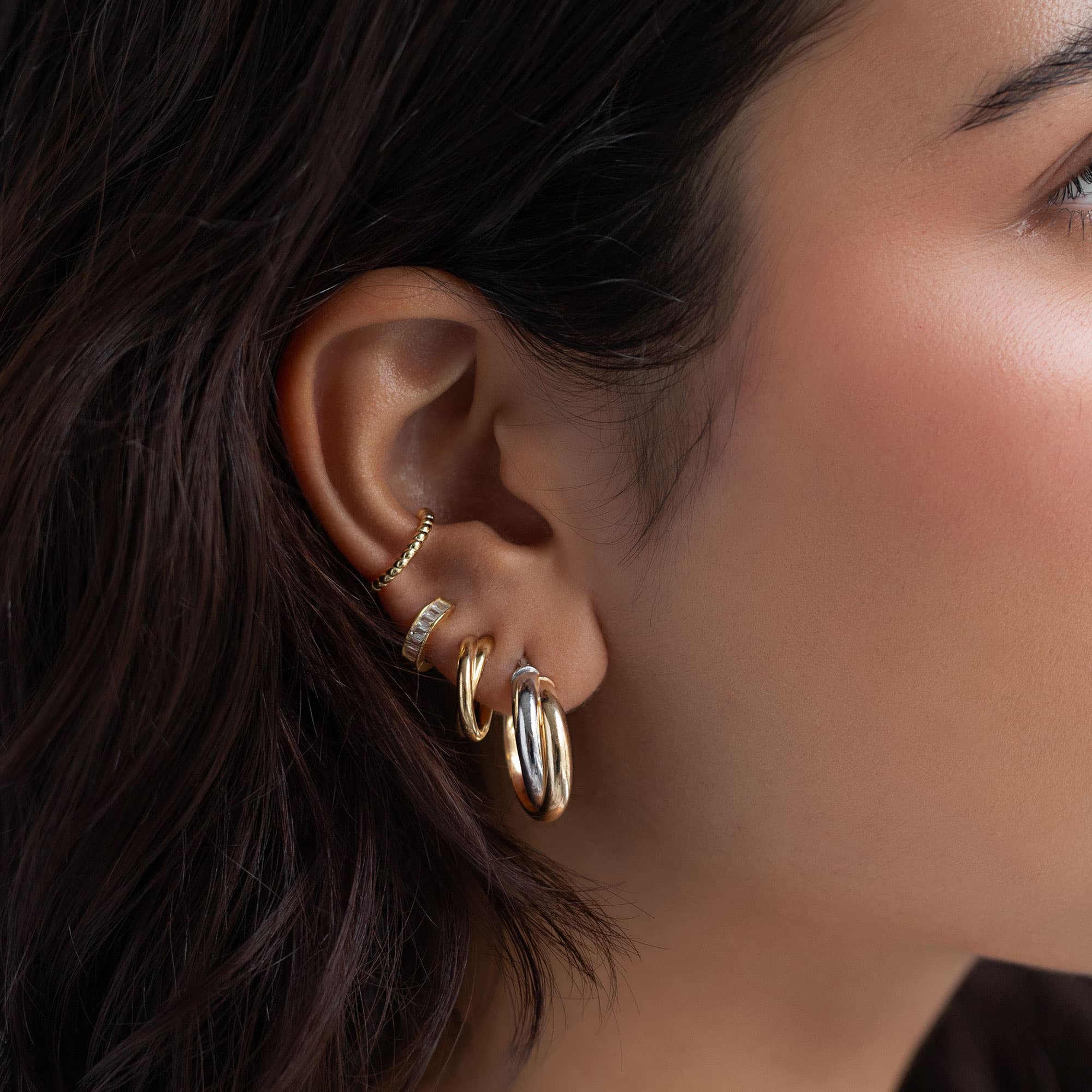 Gold vermeil and silver twist hoop in an ear stack, shown on a model's lobe