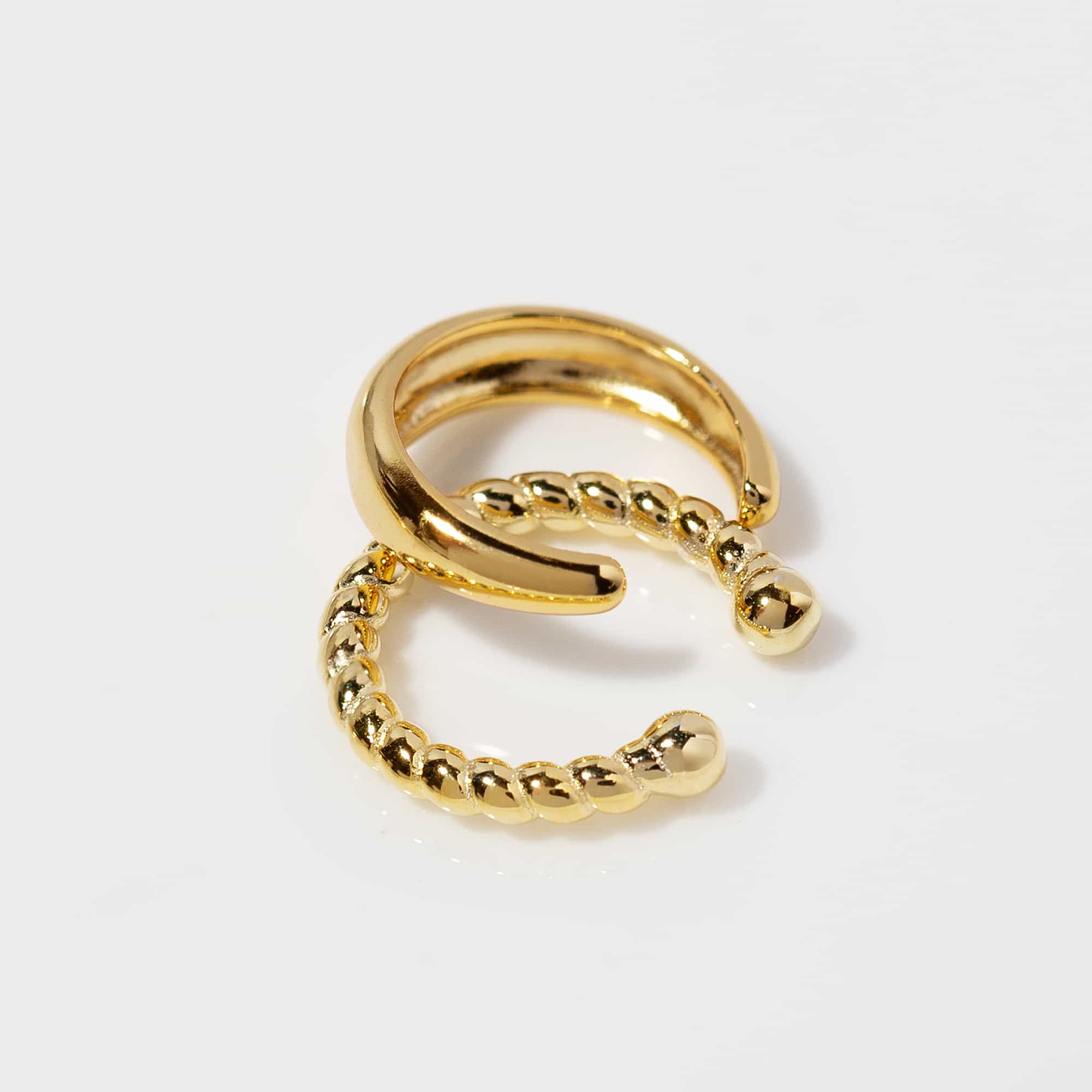 Gold vermeil rope ear cuff with a twisted beaded band and smooth wrap, on a white background