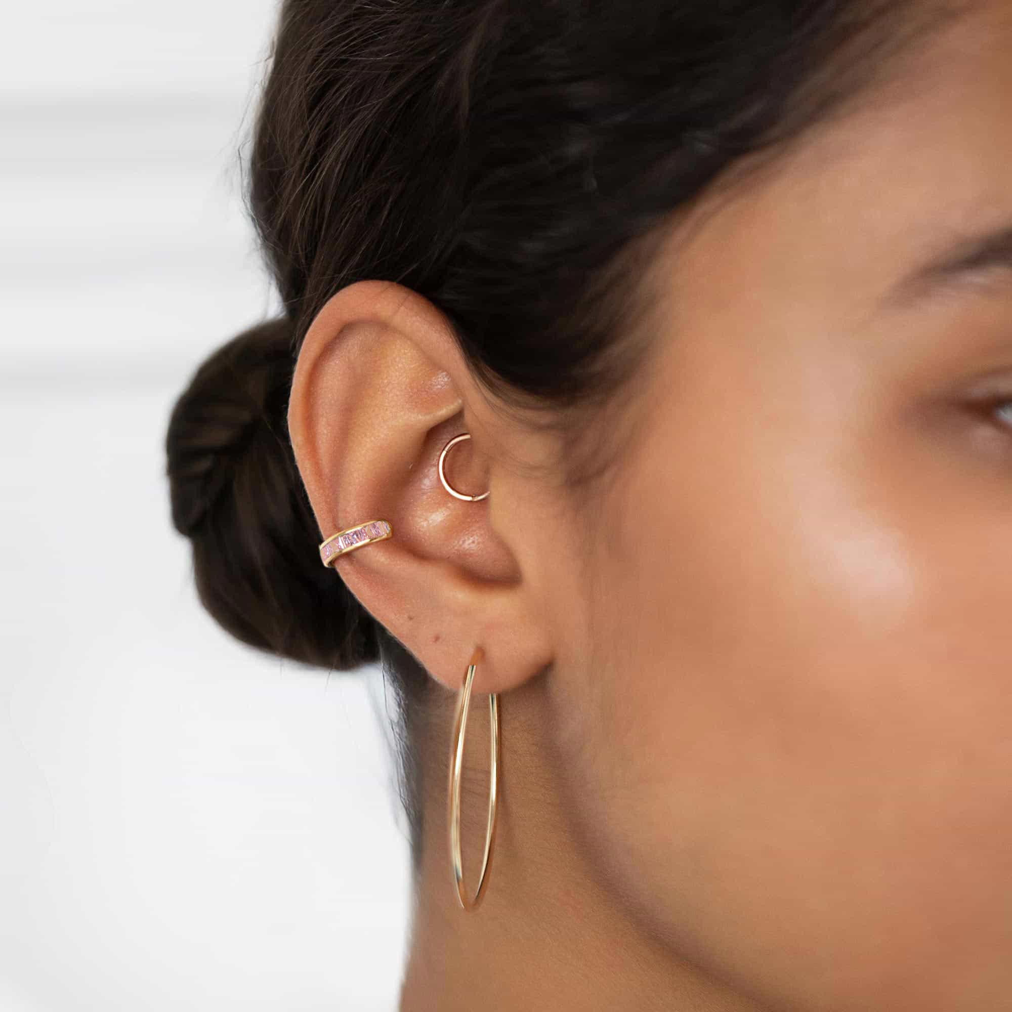 Gold vermeil princess cut pink sapphire ear cuff with pink stones, shown on a model's ear