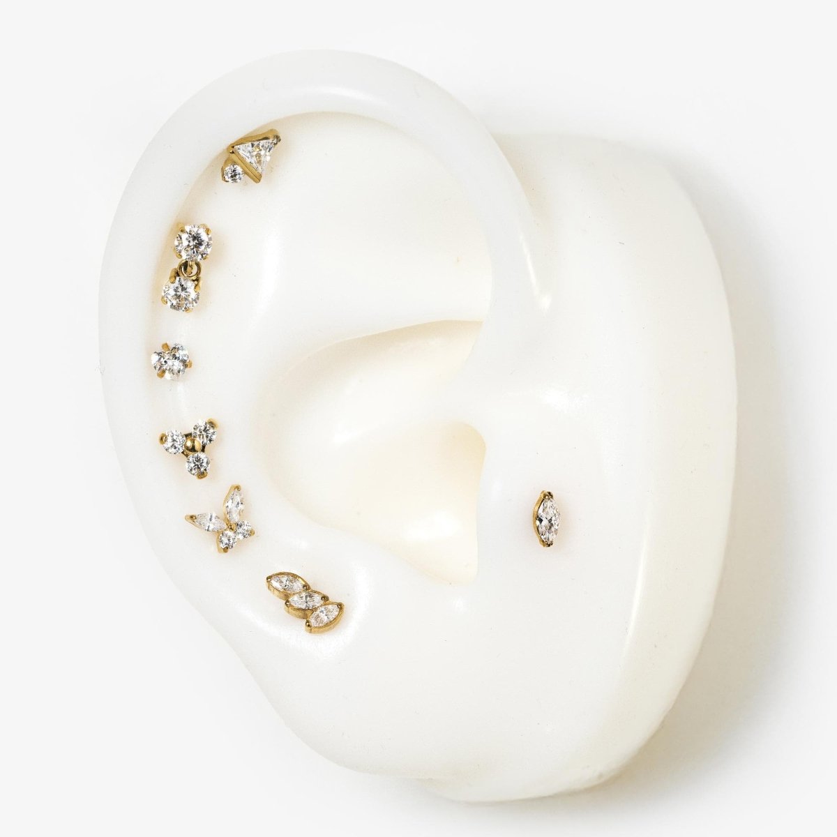 Gold titanium triangle flat back studs with clear stones, shown on a silicone ear display