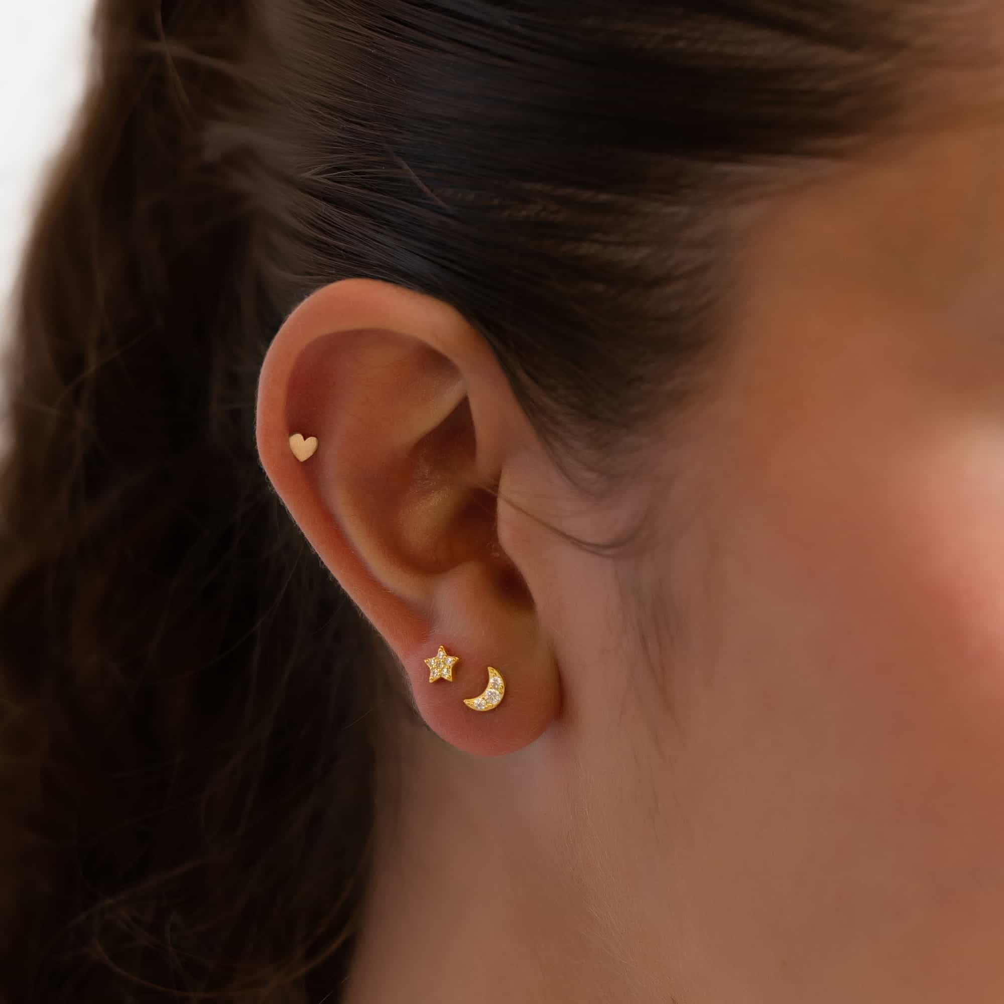 Gold vermeil pavé star and moon flat back studs shown in a model's lobe stack