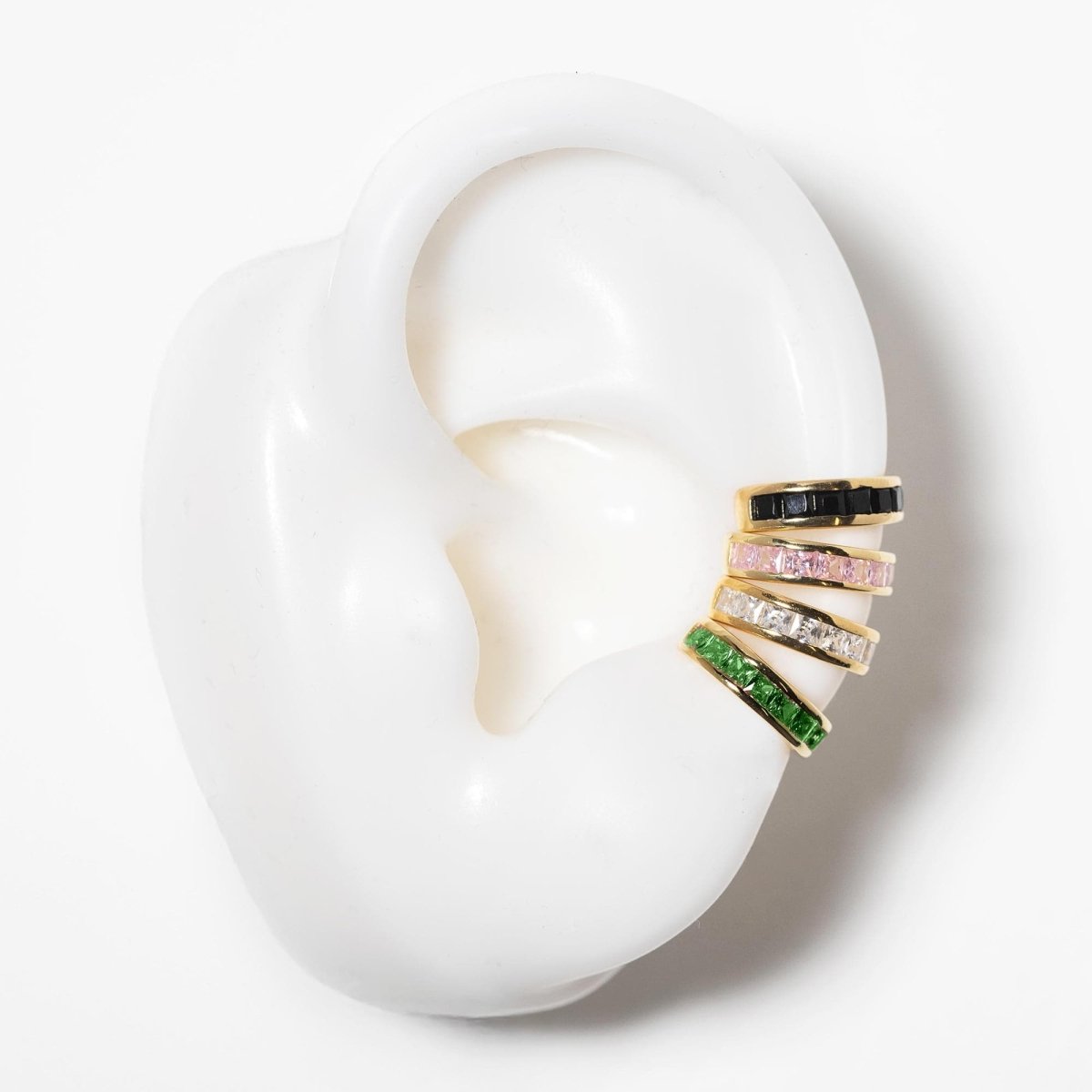 Gold vermeil princess cut emerald ear cuff in a stack of four, shown on a silicone ear display