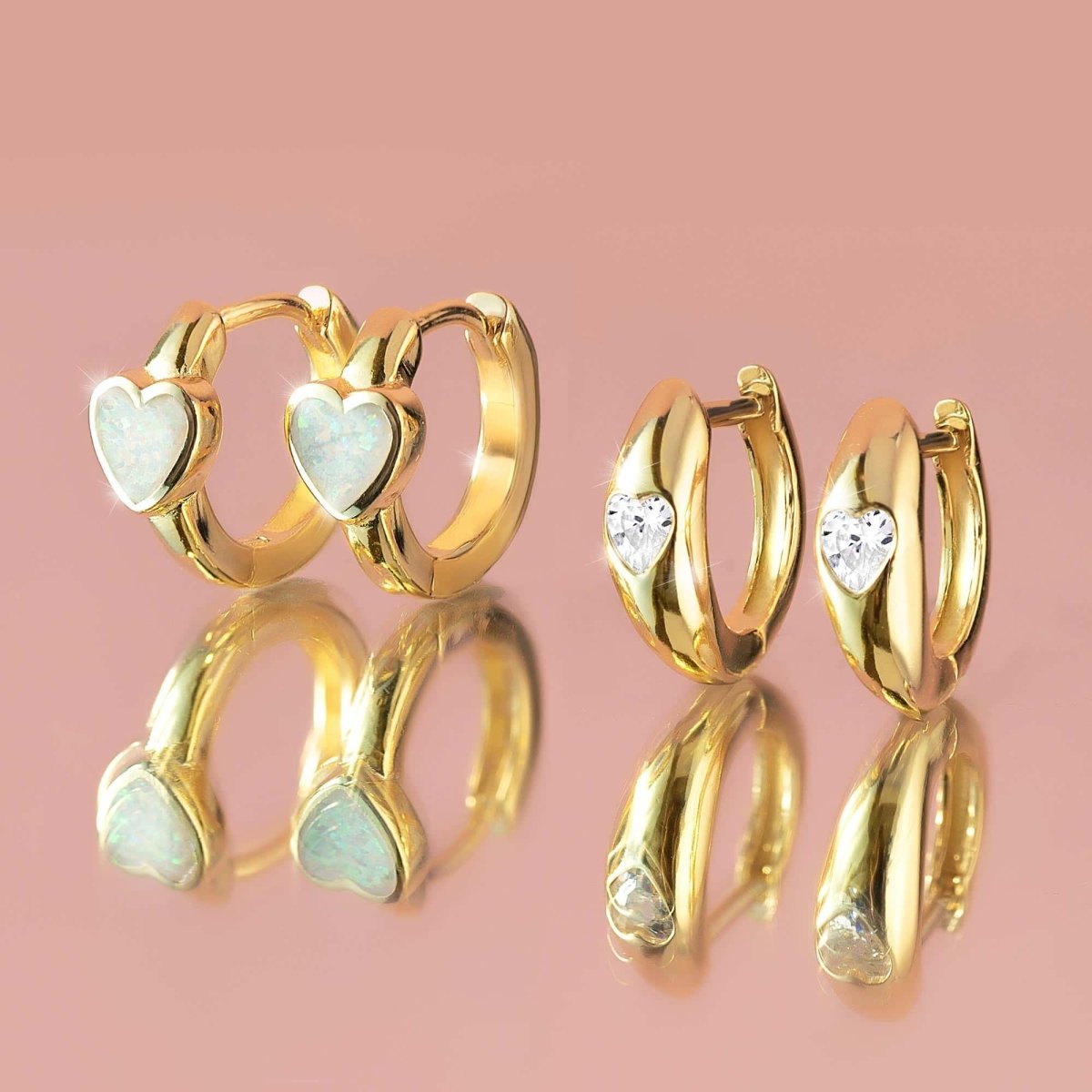 Gold vermeil opal heart huggie hoops beside clear heart-stone huggies, close-up detail
