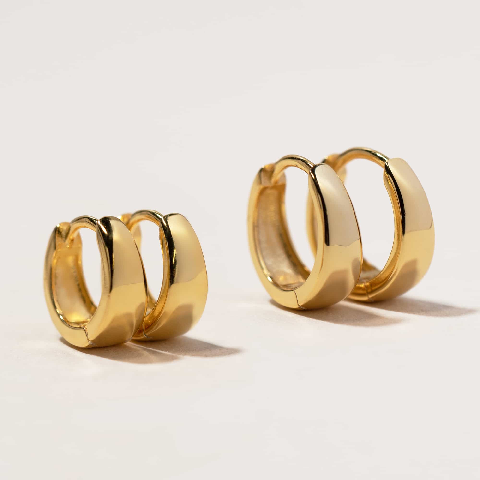Gold vermeil teardrop huggie hoops in two sizes, on a white background