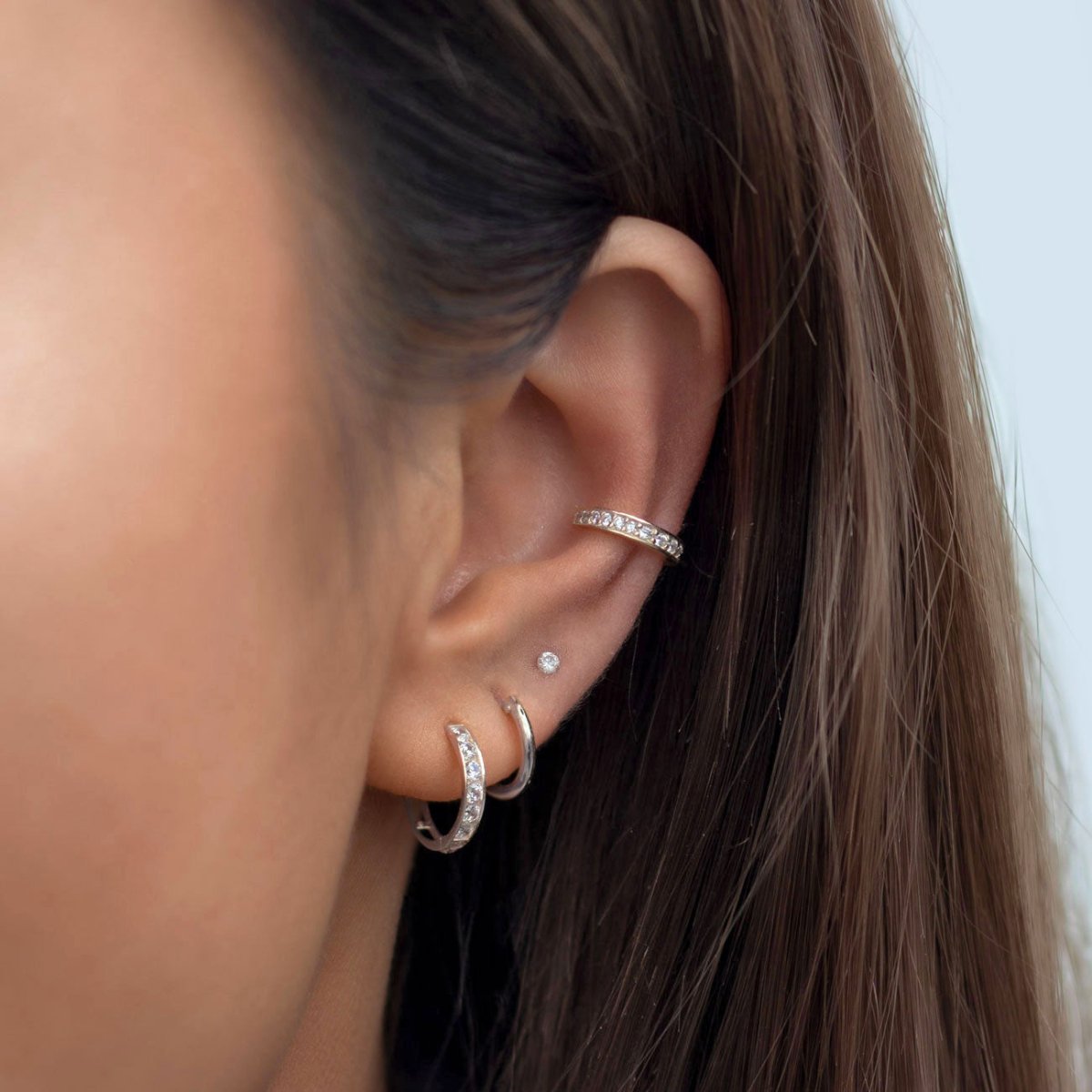 Sterling silver pavé ear cuff with white zirconia, shown on a model's upper ear