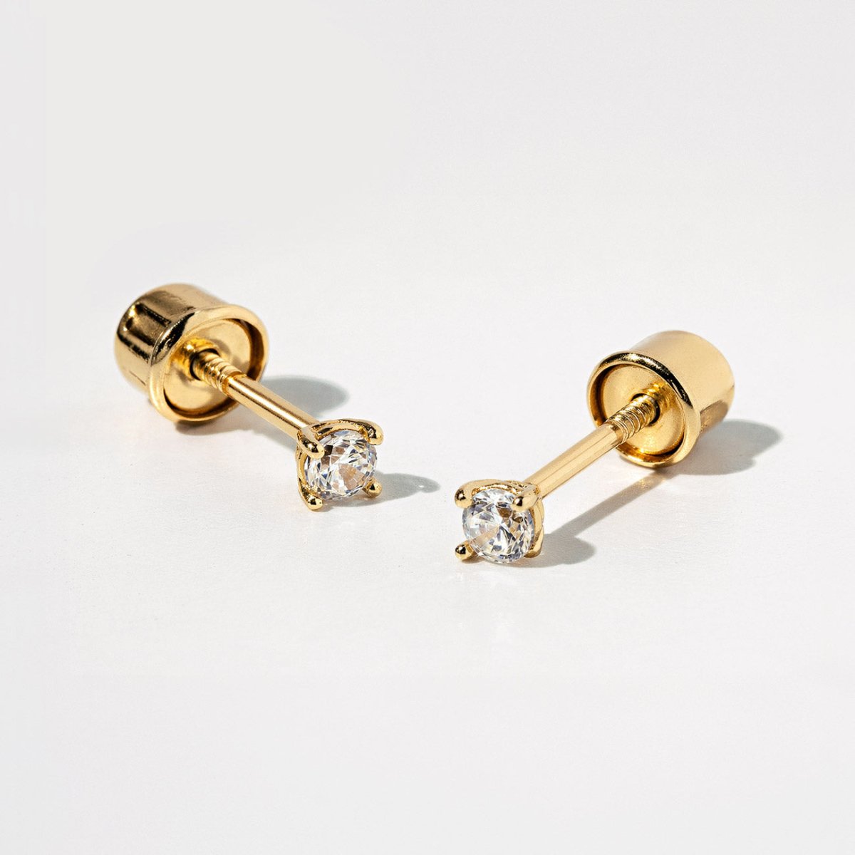 14K gold solitaire screw-back stud earrings with round white sapphires, on a white background