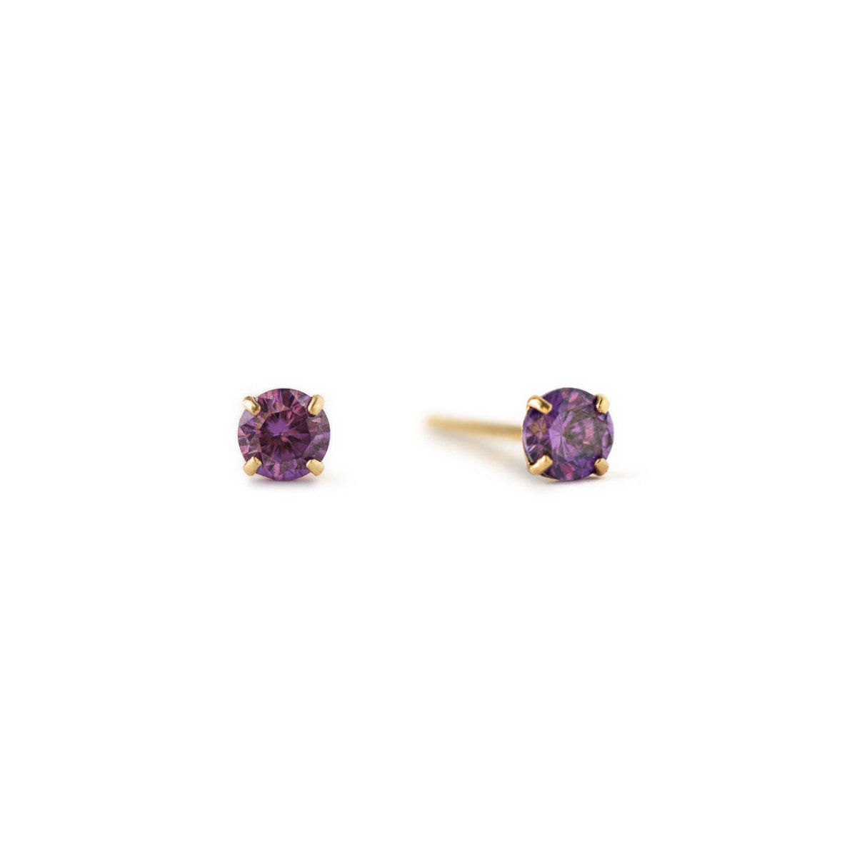 14K gold tiny alexandrite stud earrings with round purple stones in four-prong settings, on a white background
