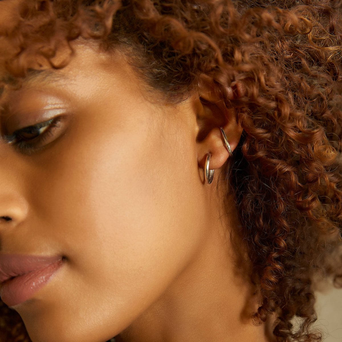 Sterling silver thin hoop and ear cuff shown on a model's ear