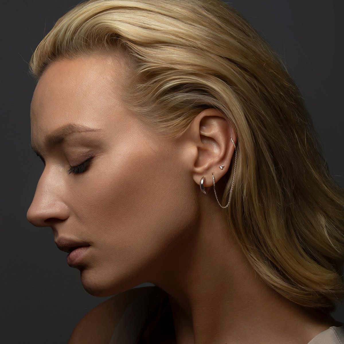 14K white gold diamond double huggie chain earring shown on a model's ear in profile