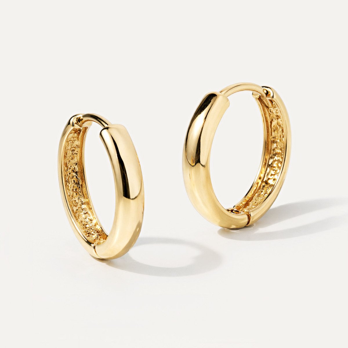 14K gold mini huggie hoops with a hinged closure, shown at an angle on a white background