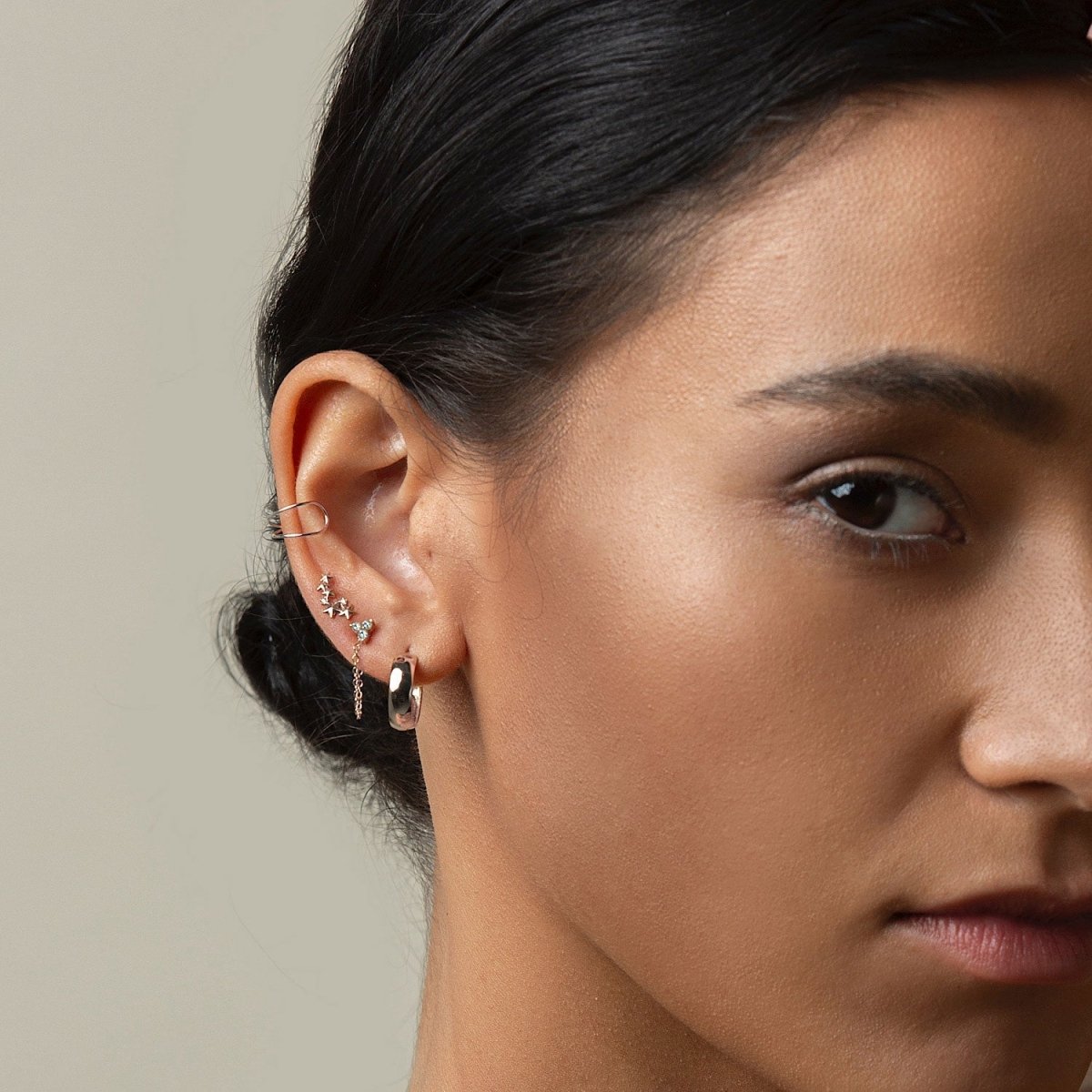 14K white gold diamond studs styled with an ear cuff and a chunky hoop, shown on a model's ear