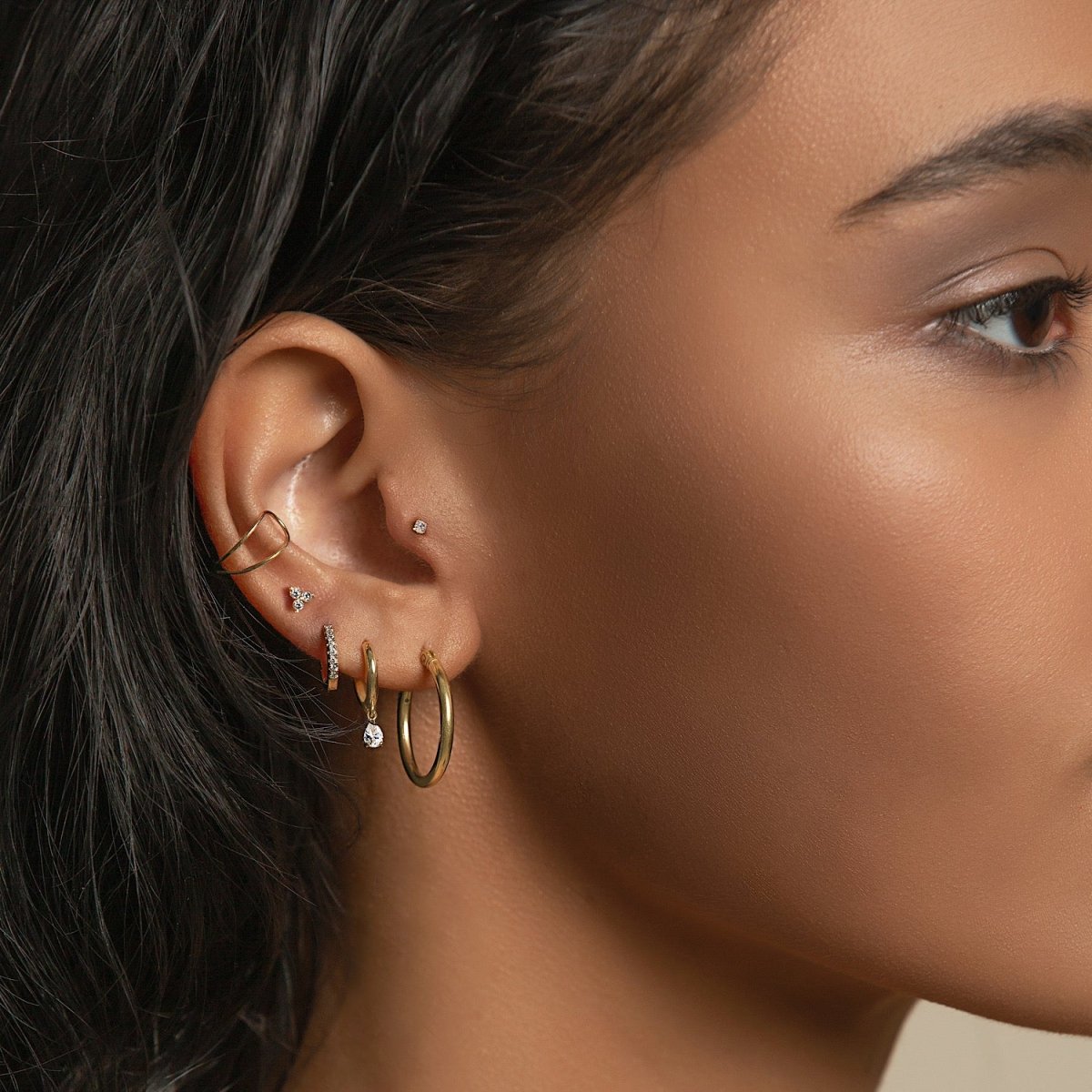 14K gold double-band ear cuff worn on the upper ear, shown on a model's ear