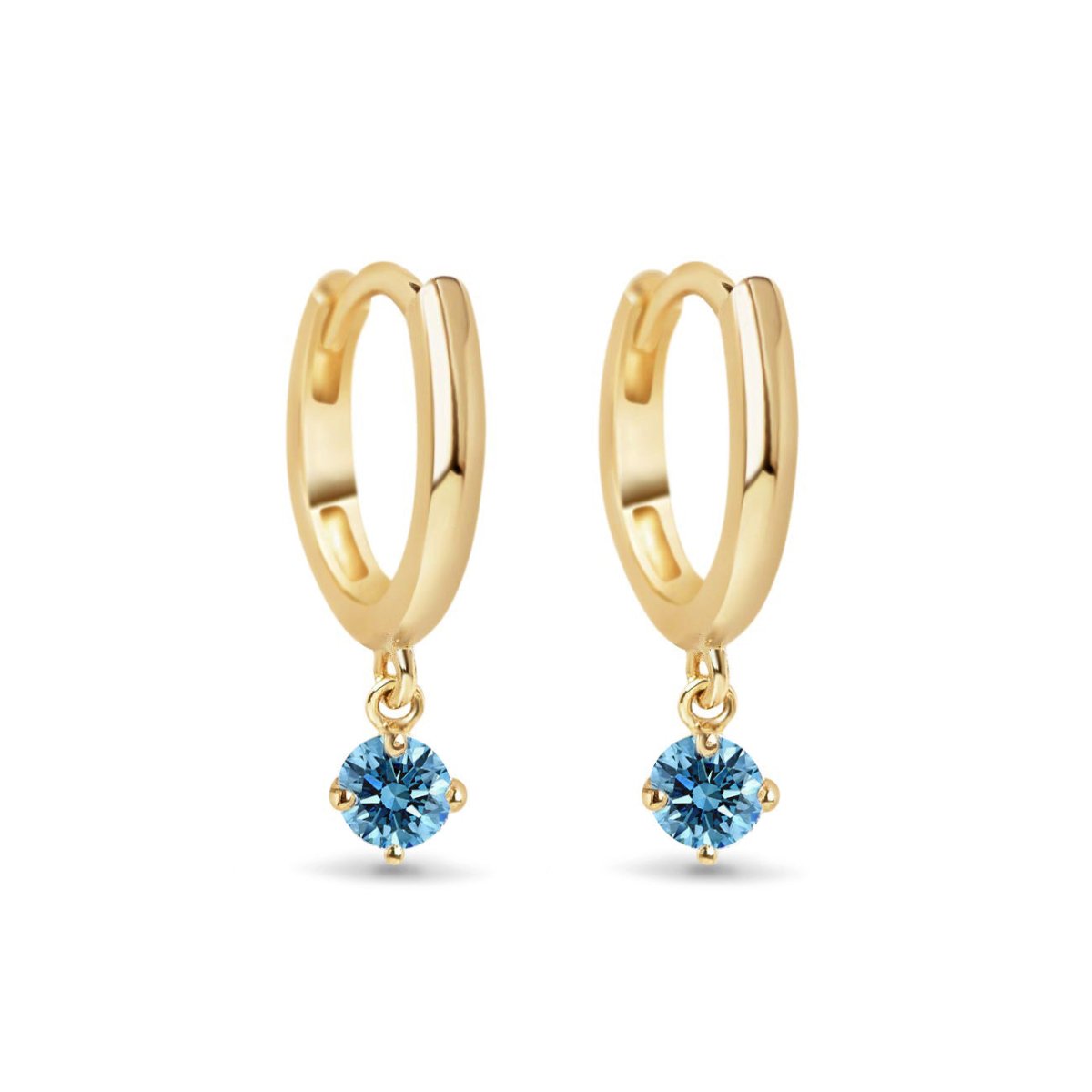 Pair of 14K gold huggie hoops with dangling round blue zircon stones, on a white background