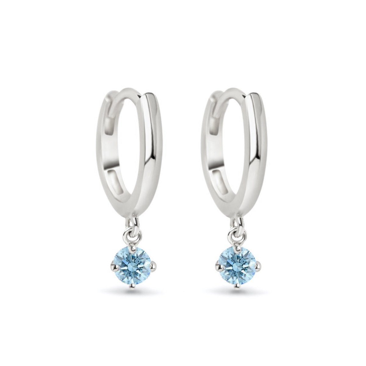 Pair of 14K white gold huggie hoops with dangling round aquamarine stones, on a white background
