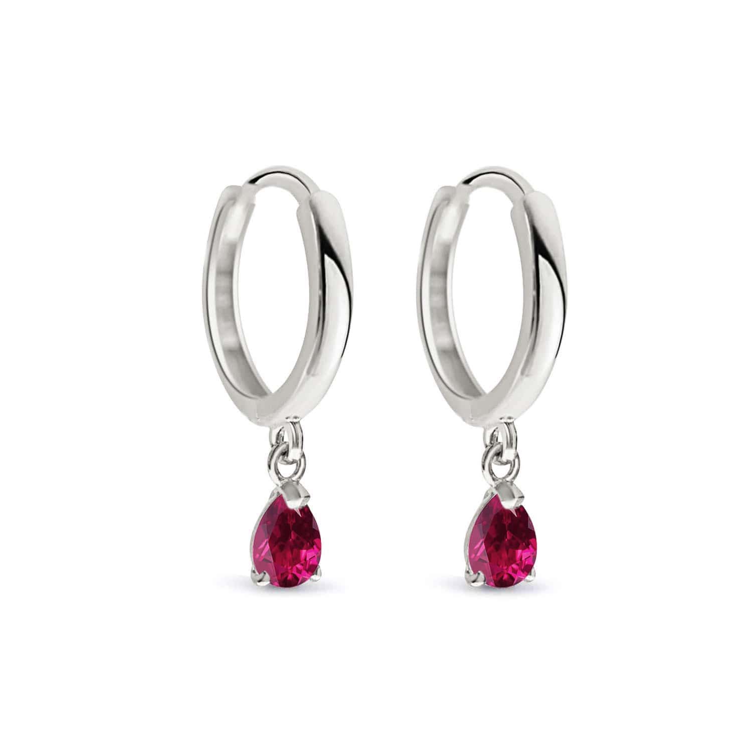 14K white gold huggie hoops with pear-shaped red ruby drops, on a white background