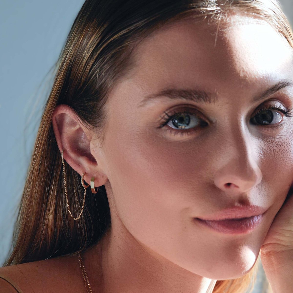 14K gold diamond pavé double huggie chain earring shown on a model's ear