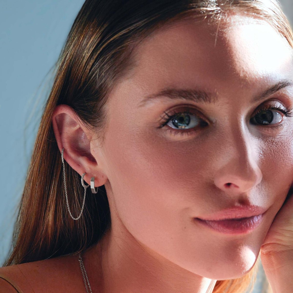 14K white gold diamond pavé double huggie chain earring shown on a model's ear