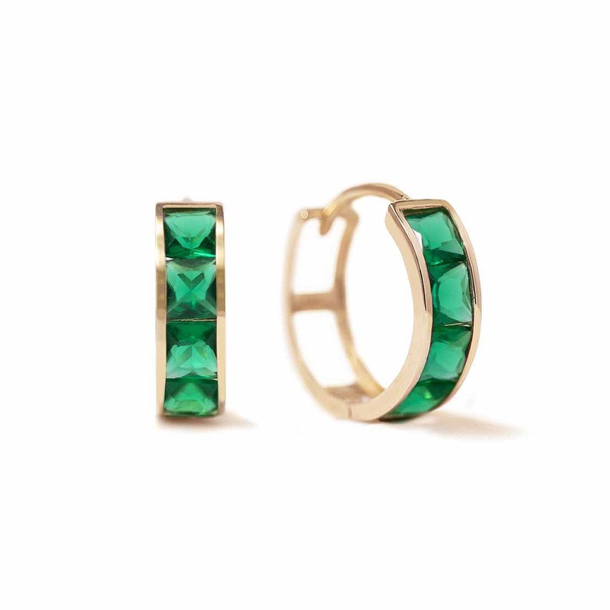 Pair of 14K gold huggie hoops with square green emerald stones, on a white background